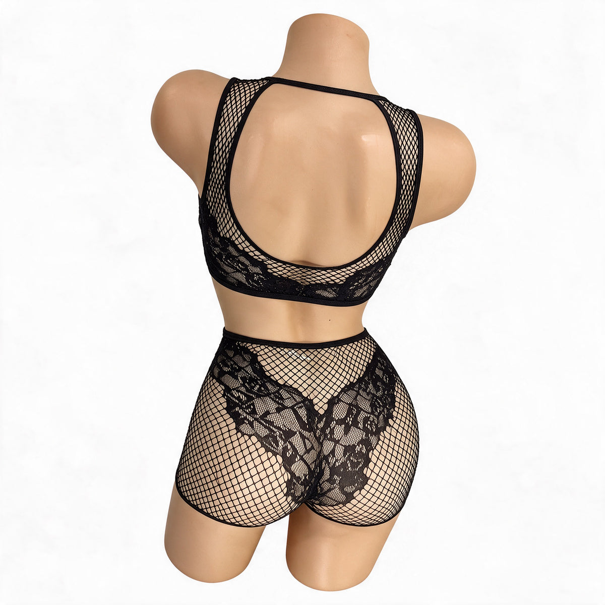 Back view of the Black Carmen fishnet and lace crop top with open racerback and lace boy shorts on a mannequin - Golddiggers Boutique