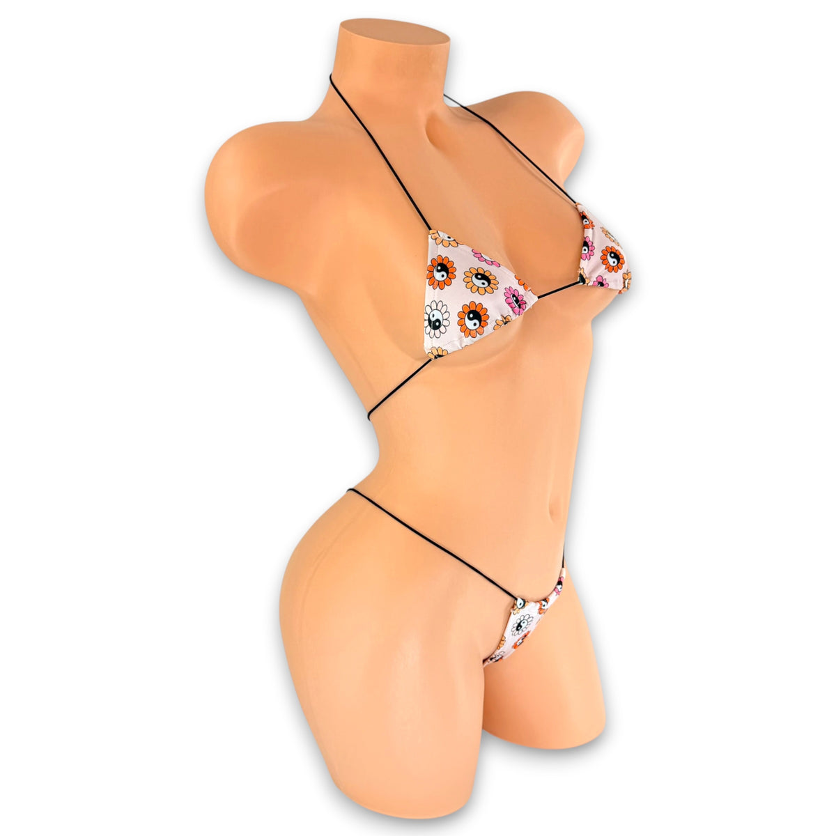 Blush retro daisy yin-yang print micro 'kini with black strings on mannequin, angled side view - Golddiggers Boutique