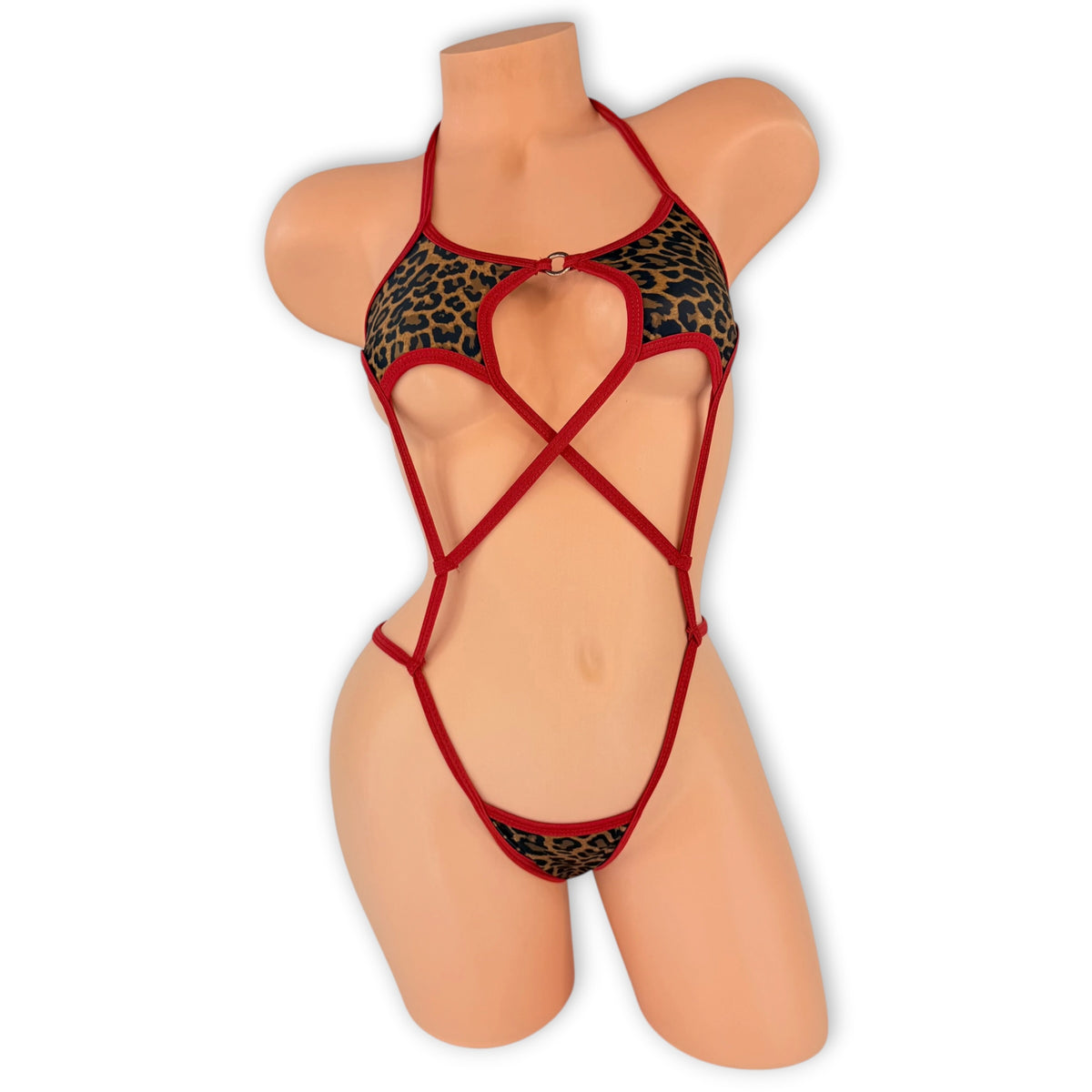 Leopard Reina slingshot bodysuit with red trim crisscross straps and silver O-ring, front view on mannequin