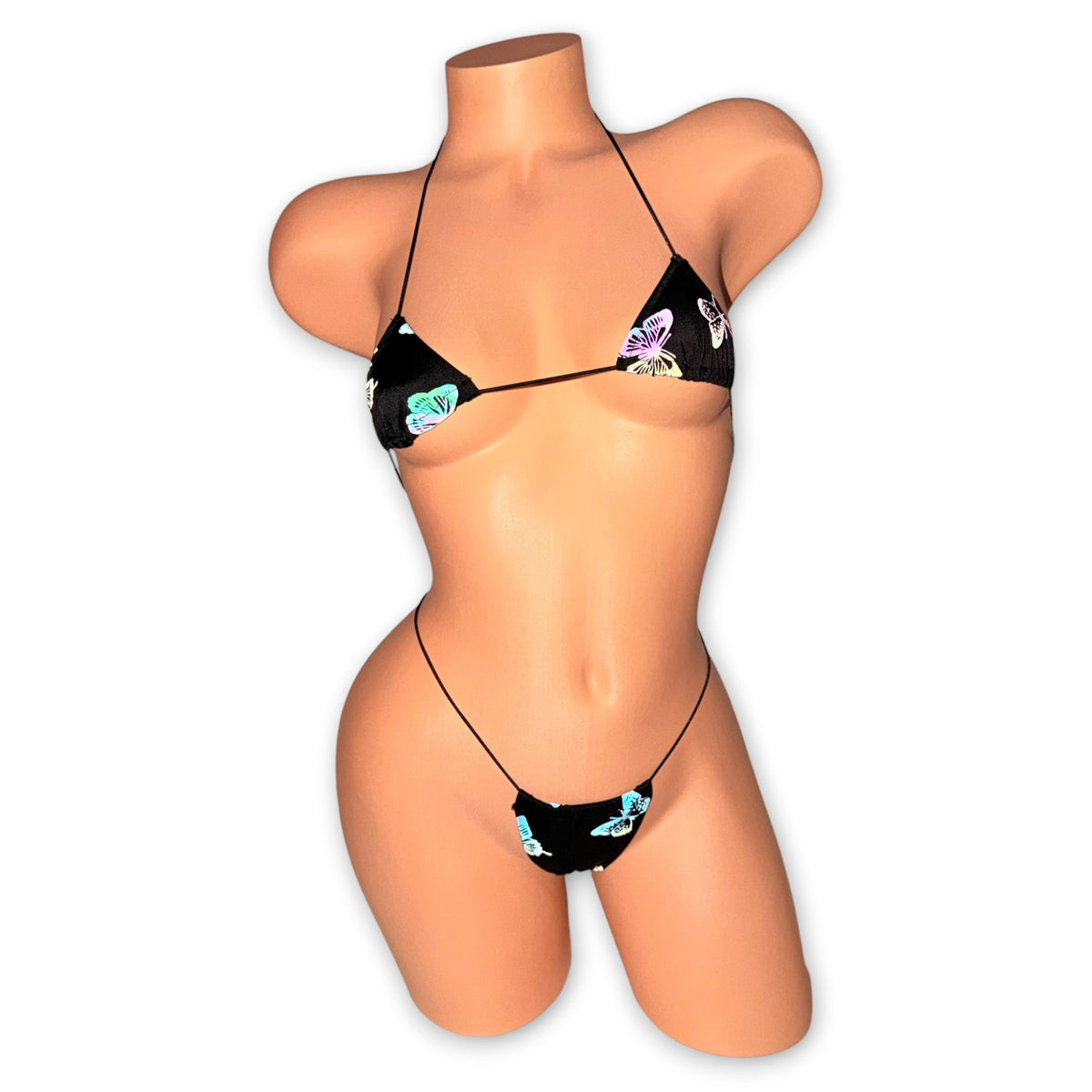Black reflective butterfly micro bikini and g-string on mannequin, front view with butterflies glowing - Golddiggers Boutique