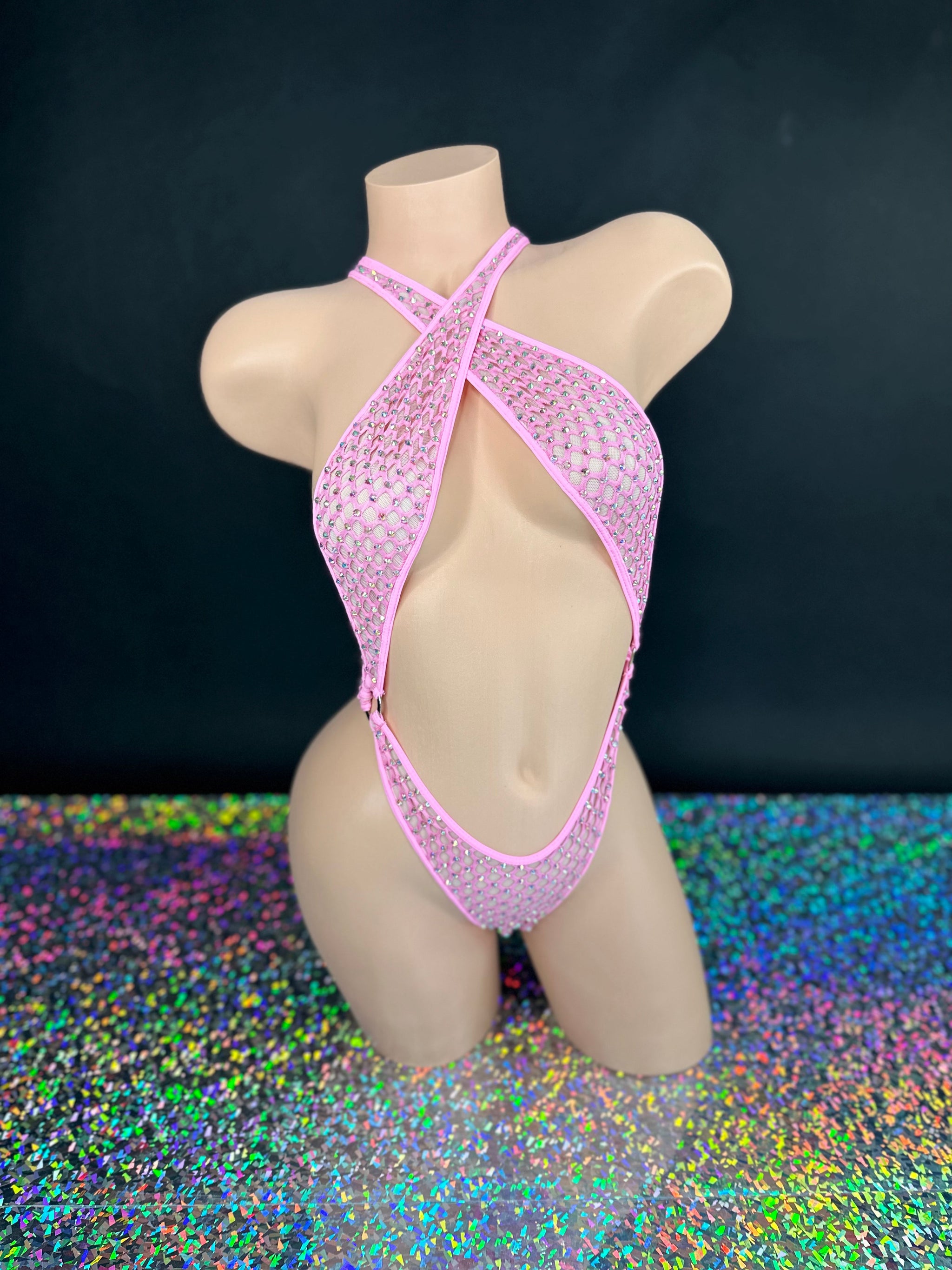 Bubble gum pink Ann criss-cross bodysuit, front view on dark background with holographic floor - Golddiggers Boutique