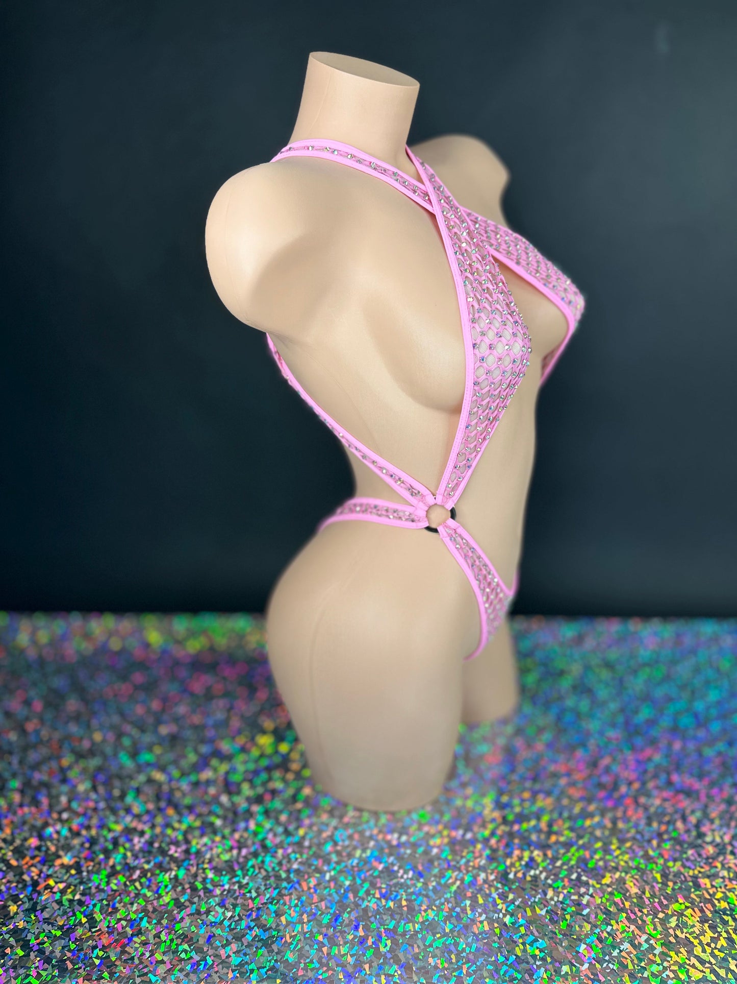 Bubble gum pink Ann criss-cross bodysuit, side view on dark background - Golddiggers Boutique