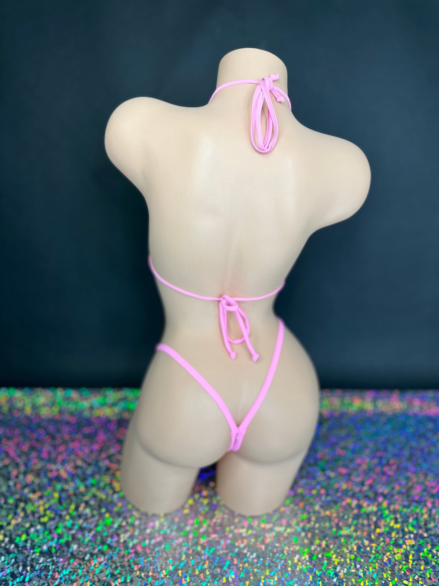 Bubble gum pink Katie 'kini, back view of ties and g-string on dark background with holographic floor - Golddiggers Boutique
